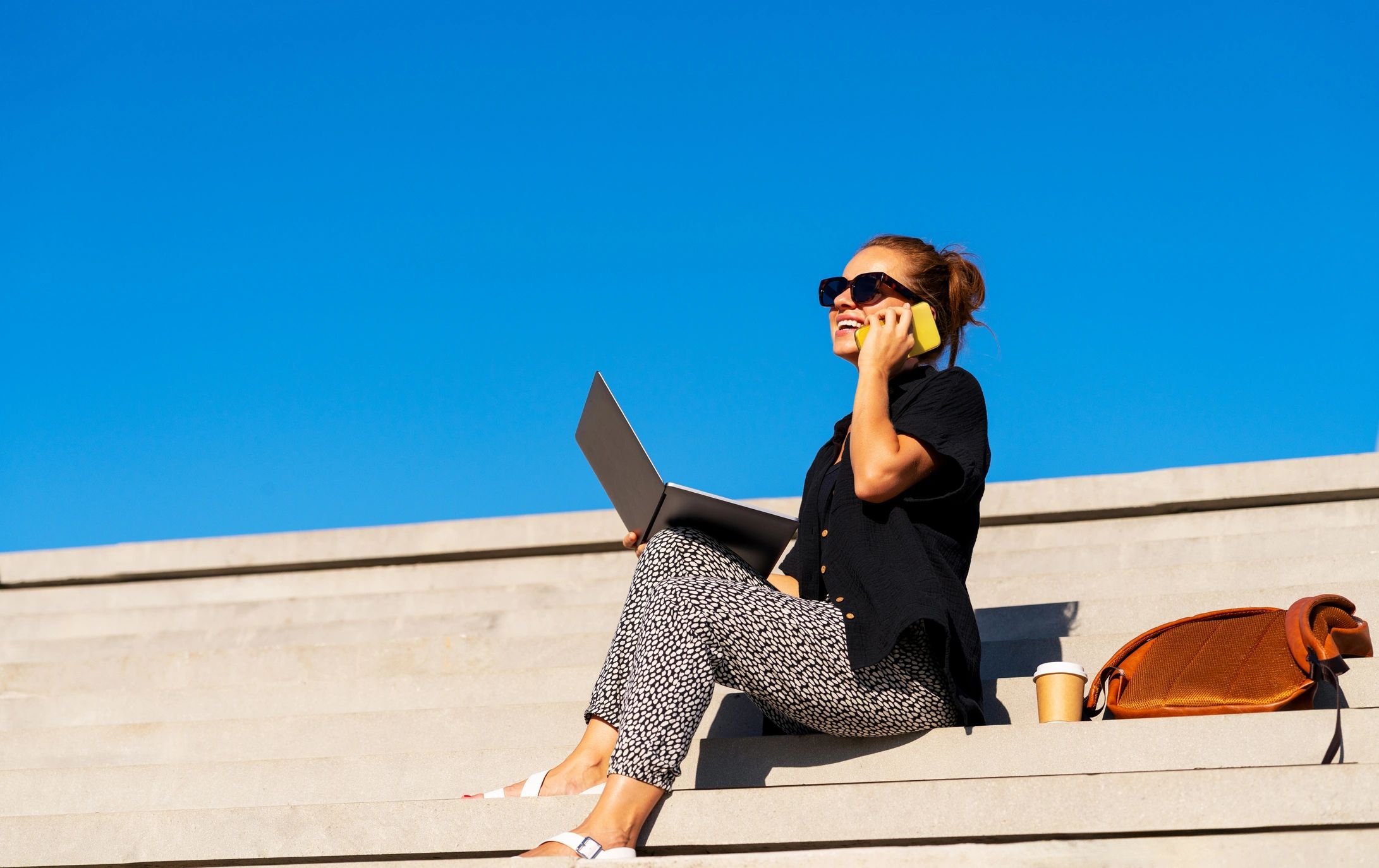 Remote-working mom with laptop representing freedom-based business life